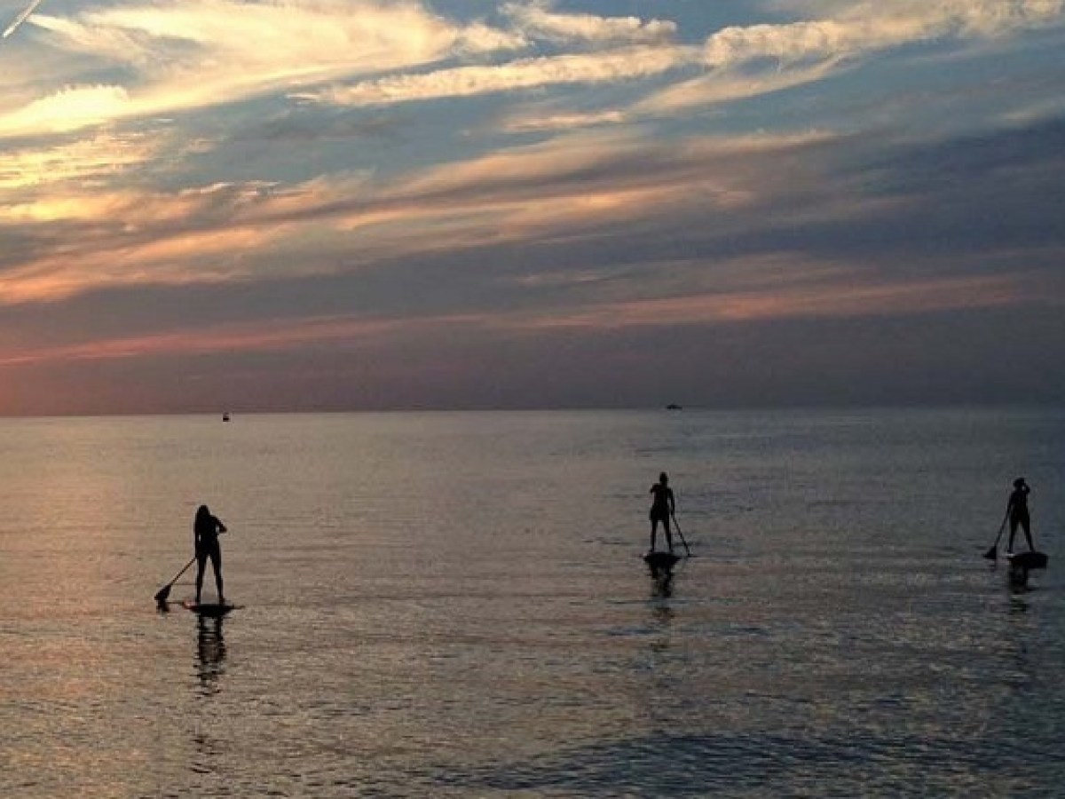 a group of people standing next to a body of water