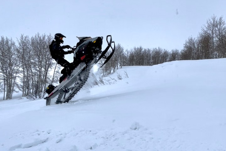 a man flying through the air on a snow covered slope