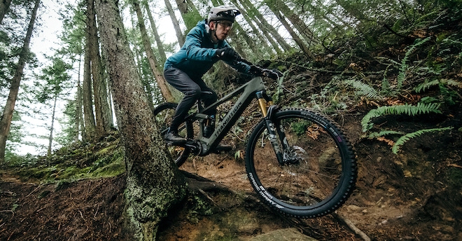 a man riding a bike down a dirt road