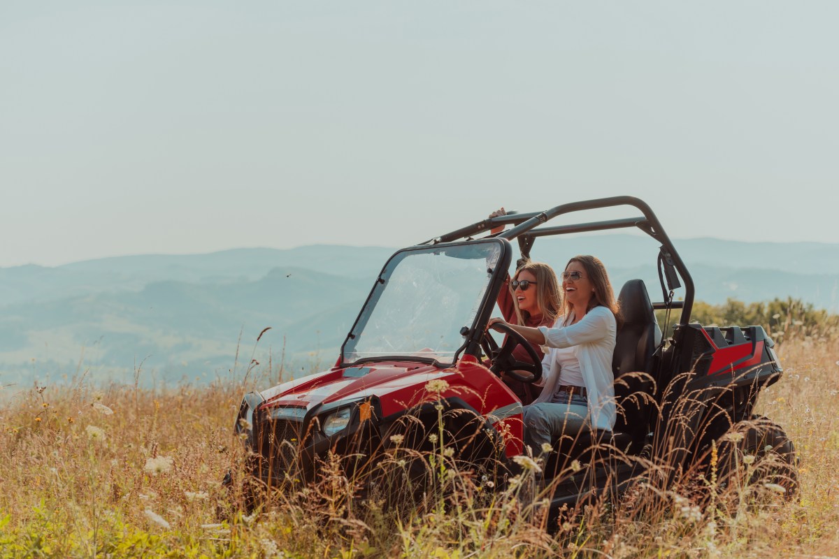 Two women happily enjoying a beautiful sunny day while driving in a Can-Am Commander XT offroading in Park City, Utah