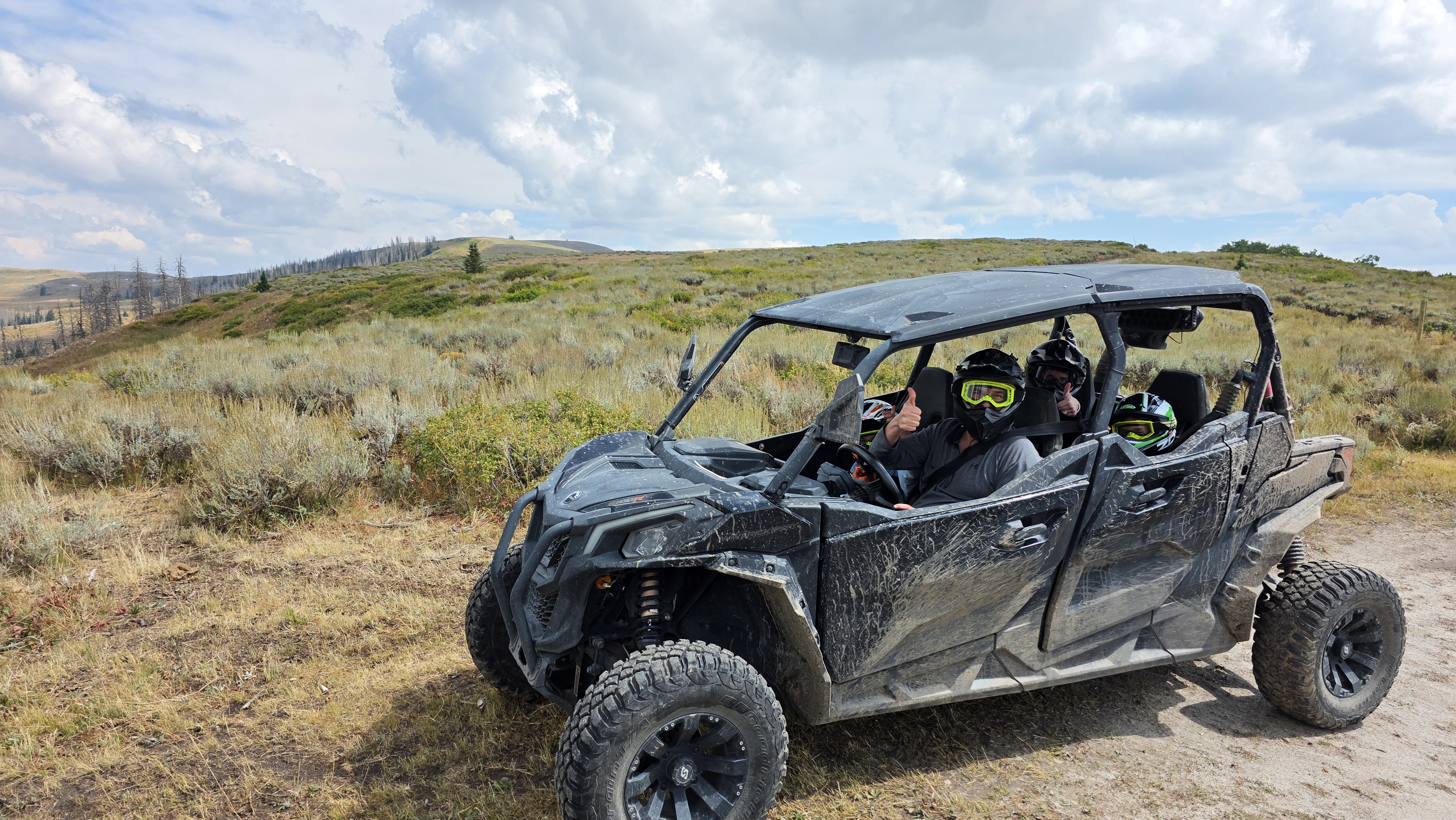 A driver giving the thumbs up in a Can-Am UTV with 3 passengers in Heber City, UT.