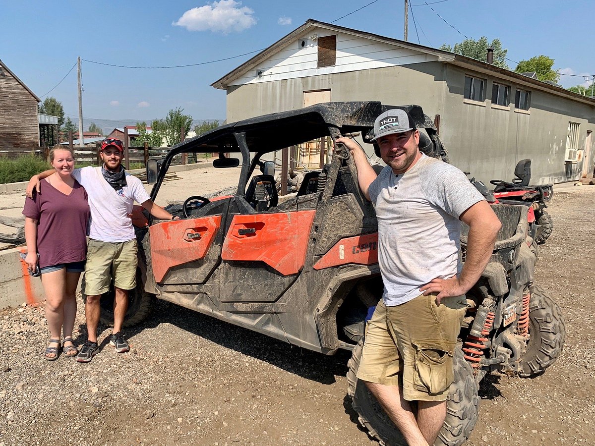 A photo of three people standing on both sides of a Can-AM UTV in Heber City, Utah.