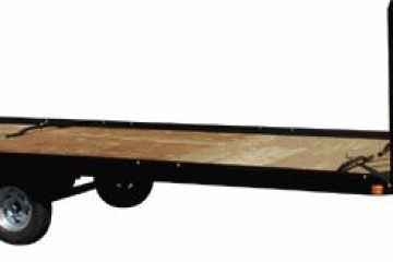 Flatbed trailer with dual axles and metal frame.